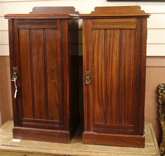 A pair of mahogany pedestal bedside cupboards, each with raised panel to the top and with single door, on W.38cm